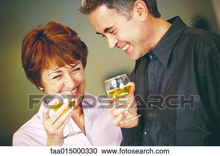 Senior couple holding up glasses of white wine View Large Photo Image Stock Image - Senior couple holding up glasses of white wine. Fotosearch
