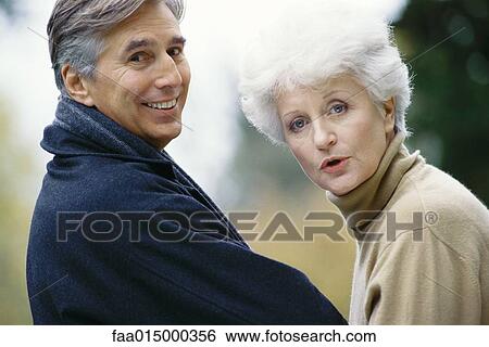 Senior couple, looking over shoulder at camera View Large Photo Image Stock Photograph - Senior couple, looking over shoulder at camera. Fotosearch