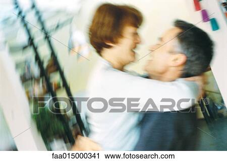 Stock Image - Senior couple, man lifting woman up, blurred motion. Fotosearch