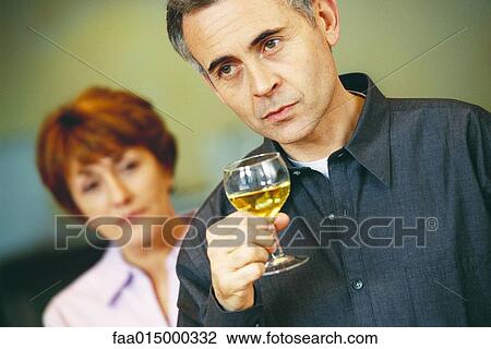 Senior man holding glass of wine, senior woman looking at him in background View Large Photo Image Stock Image - Senior man holding glass of wine, senior woman looking at him in background. Fotosearch