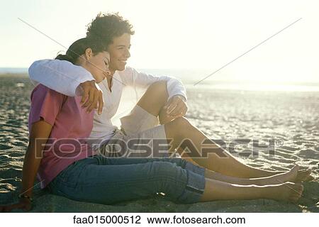 Teenage couple sitting on beach together View Large Photo Image Stock Image - Teenage couple sitting on beach together. Fotosearch