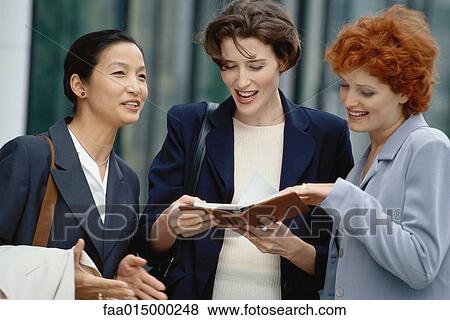 Three businesswoman looking at agenda View Large Photo Image Stock Photo - Three businesswoman looking at agenda. Fotosearch