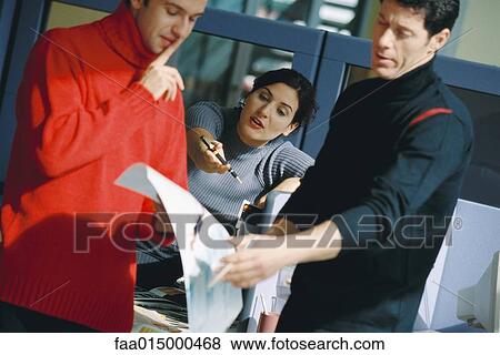 Three colleagues discussing document View Large Photo Image Stock Photo - Three colleagues discussing document. Fotosearch