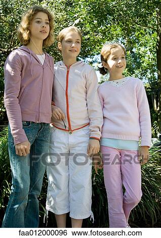 Three girls standing side by side View Large Photo Image Stock Photograph - Three girls standing side by side. Fotosearch
