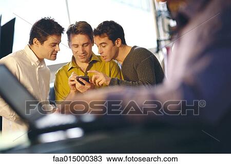 Three young men using electronic organizer, laptop user in foreground View Large Photo Image Stock Image - Three young men using electronic organizer, laptop user in foreground. Fotosearch