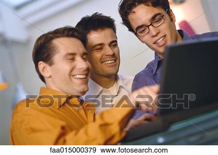 Three young men using laptop together View Large Photo Image Stock Photo - Three young men using laptop together. Fotosearch