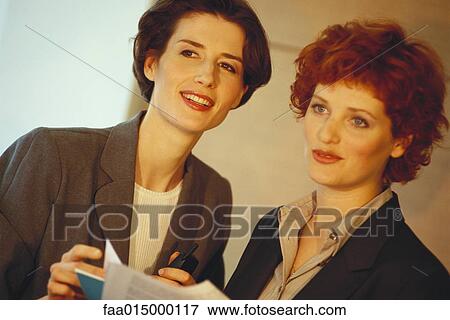 Stock Photo - Two business women, looking out of frame. Fotosearch