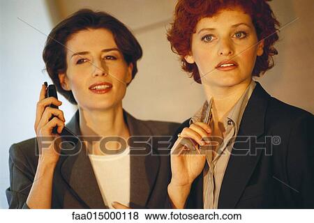 Two business women, looking out of frame View Large Photo Image Stock Photo - Two business women, looking out of frame. Fotosearch