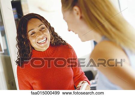 Two female colleagues laughing View Large Photo Image Stock Photo - Two female colleagues laughing. Fotosearch