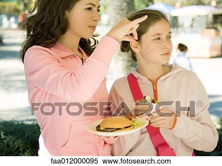 Two girls eating fast food View Large Photo Image Stock Photography - Two girls eating fast food. Fotosearch