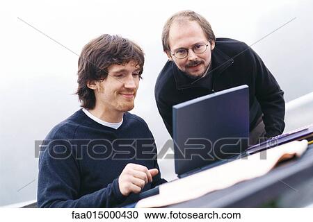 Two men using laptop View Large Photo Image Stock Image - Two men using laptop. Fotosearch