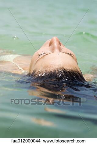 Woman floating in water, close-up View Large Photo Image Picture - Woman floating in water, close-up. Fotosearch
