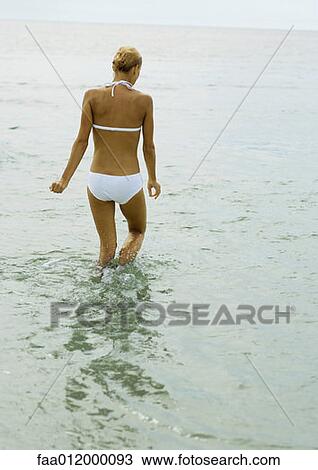 Woman in bikini, knee deep in water, rear view View Large Photo Image Stock Image - Woman in bikini, knee deep in water, rear view. Fotosearch