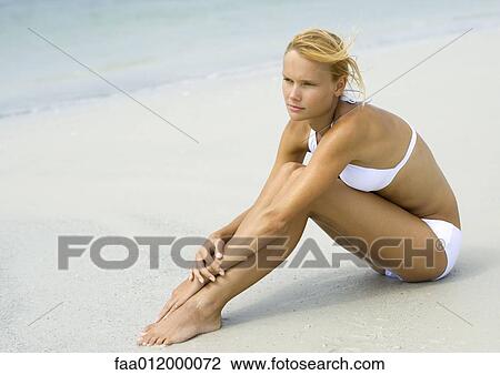 Woman in bikini sitting on beach, hugging knees, full length View Large Photo Image Stock Image - Woman in bikini sitting on beach, hugging knees, full length. Fotosearch