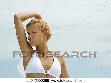 Woman in bikini standing with arm up, looking away View Large Photo Image Stock Photo - Woman in bikini standing with arm up, looking away. Fotosearch