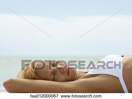 Woman in bikini with eyes closed, sea in background View Large Photo Image Stock Photo - Woman in bikini with eyes closed, sea in background. Fotosearch