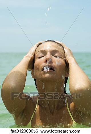 Woman in sea, hands on head and eyes closed, close-up View Large Photo Image Stock Photograph - Woman in sea, hands on head and eyes closed, close-up. Fotosearch