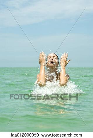 Woman in sea splashing face View Large Photo Image Stock Image - Woman in sea splashing face. Fotosearch