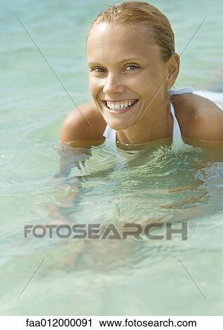 Woman in water, smiling at camera View Large Photo Image Stock Image - Woman in water, smiling at camera. Fotosearch
