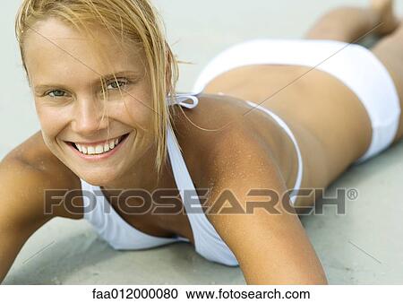 Woman lying on beach, smiling, close-up View Large Photo Image Stock Image - Woman lying on beach, smiling, close-up. Fotosearch