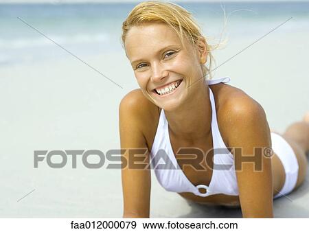 Woman lying on beach, smiling View Large Photo Image Stock Photo - Woman lying on beach, smiling. Fotosearch