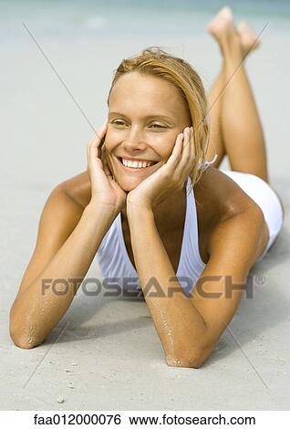Woman lying on beach, smiling View Large Photo Image Stock Photograph - Woman lying on beach, smiling. Fotosearch