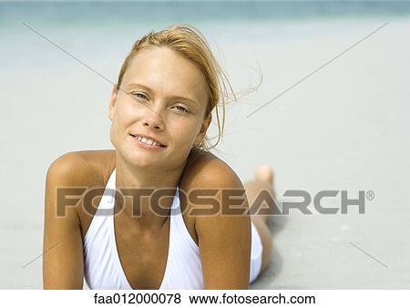 Stock Photo - Woman lying on beach. Fotosearch