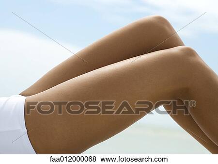 Woman reclining with knees up, close-up of bare legs View Large Photo Image Stock Photo - Woman reclining with knees up, close-up of bare legs. Fotosearch