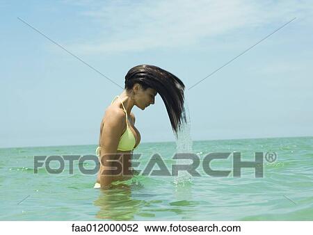 Woman standing in sea, flipping wet hair View Large Photo Image Stock Image - Woman standing in sea, flipping wet hair. Fotosearch