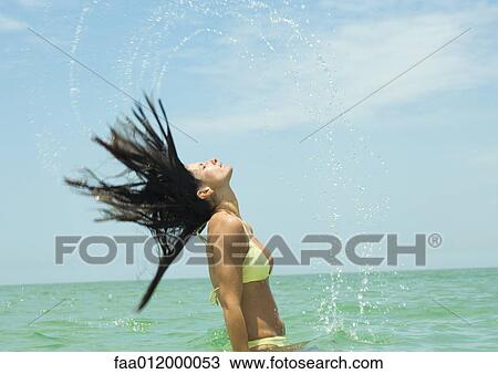 Woman standing in sea, flipping wet hair View Large Photo Image Stock Image - Woman standing in sea, flipping wet hair. Fotosearch