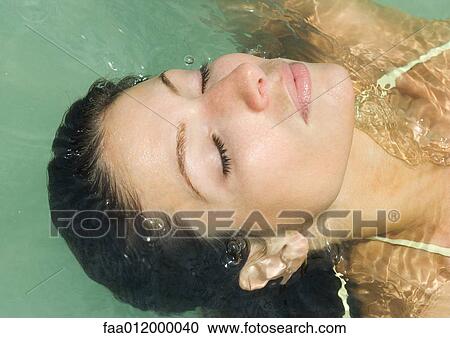 Woman with closed eyes, leaning back into water, close-up of head View Large Photo Image Stock Image - Woman with closed eyes, leaning back into water, close-up of head. Fotosearch