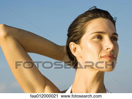 Woman with hand behind head, portrait View Large Photo Image Stock Image - Woman with hand behind head, portrait. Fotosearch