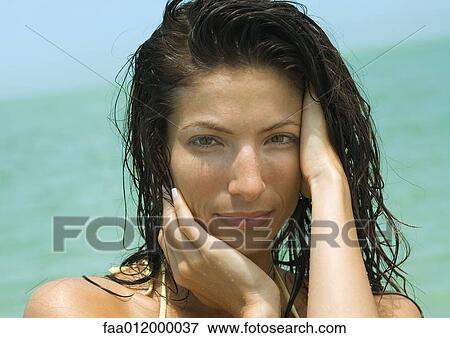 Woman with hand in wet hair, sea in background, portrait View Large Photo Image Stock Photo - Woman with hand in wet hair, sea in background, portrait. Fotosearch