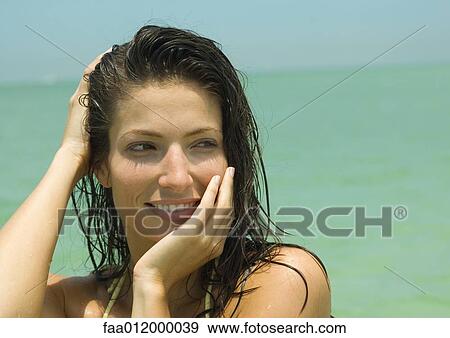 Woman with hand in wet hair, sea in background, portrait View Large Photo Image Stock Photo - Woman with hand in wet hair, sea in background, portrait. Fotosearch