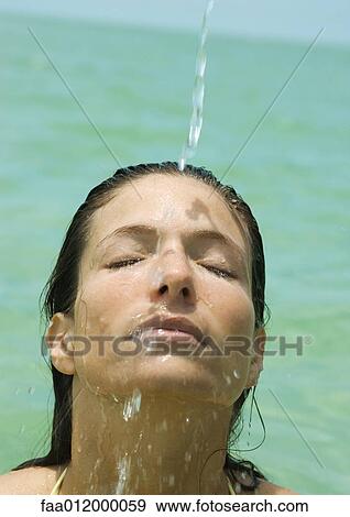 Woman's face getting wet, sea in background View Large Photo Image Stock Photo - Woman's face getting wet, sea in background. Fotosearch