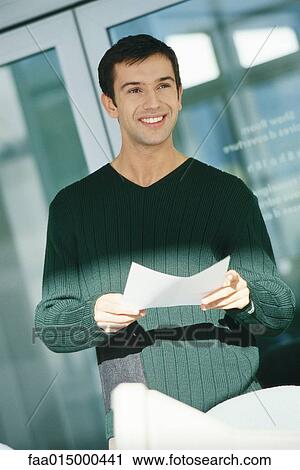 Young male office worker holding document View Large Photo Image Stock Image - Young male office worker holding document. Fotosearch