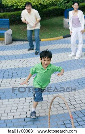 Boy chasing hoop, parents watching View Large Photo Image Stock Image - Boy chasing hoop, parents watching. Fotosearch