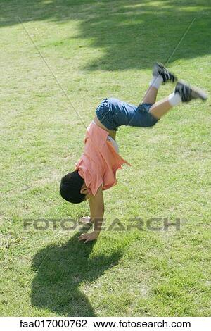 Boy doing handstand on grass View Large Photo Image Stock Image - Boy doing handstand on grass. Fotosearch