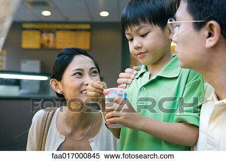 Boy eating sweet snack, parents watching View Large Photo Image Stock Photography - Boy eating sweet snack, parents watching. Fotosearch