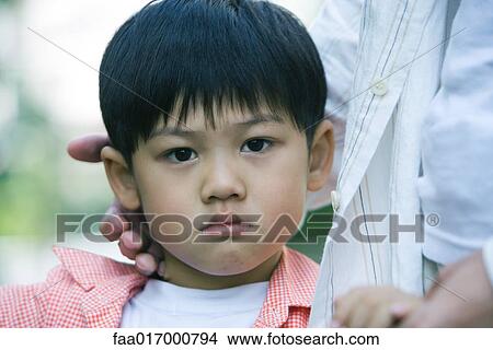 Picture - Boy frowning, head and shoulders, portrait. Fotosearch