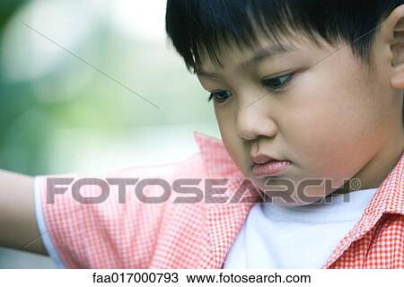 Boy frowning, head and shoulders, portrait View Large Photo Image Stock Image - Boy frowning, head and shoulders, portrait. Fotosearch