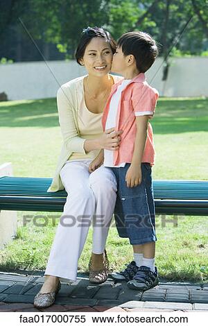 Stock Photography - Boy kissing mother on cheek, full length. Fotosearch