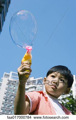 Boy making bubbles with bubble gun View Large Photo Image Picture - Boy making bubbles with bubble gun. Fotosearch