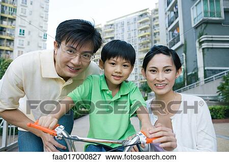 Boy on bicycle, between parents, portrait View Large Photo Image Stock Photo - Boy on bicycle, between parents, portrait. Fotosearch