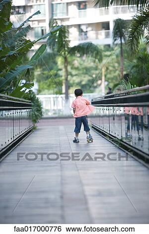 Boy playing on push scooter, full length, rear view View Large Photo Image Stock Photograph - Boy playing on push scooter, full length, rear view. Fotosearch
