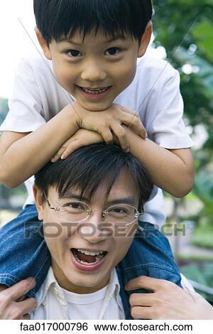 Boy riding on father's shoulders, front view, smiling at camera View Large Photo Image Stock Photograph - Boy riding on father's shoulders, front view, smiling at camera. Fotosearch