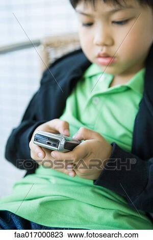 Boy using cell phone View Large Photo Image Stock Image - Boy using cell phone. Fotosearch