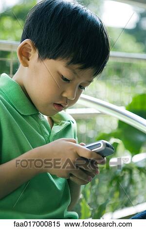 Boy using cell phone View Large Photo Image Stock Photography - Boy using cell phone. Fotosearch