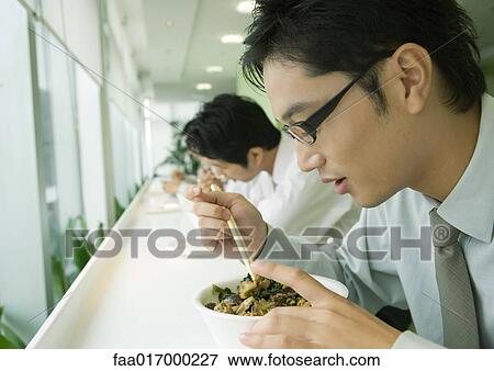 Stock Photo - Business executives eating in cafeteria. Fotosearch