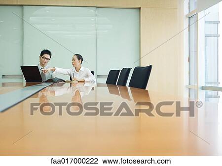 Stock Image - Business executives working in conference room. Fotosearch